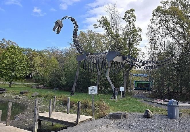 A dinosaur statue in a park

AI-generated content may be incorrect.