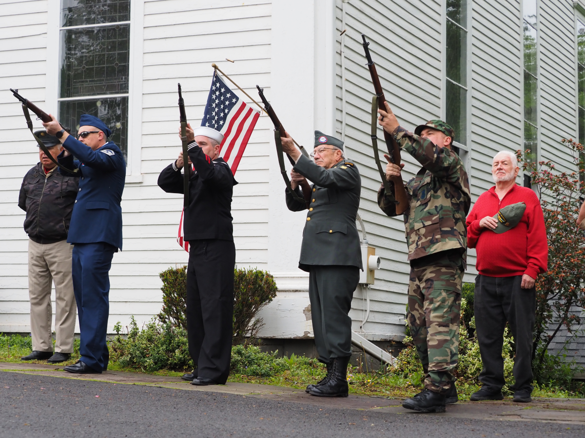 Veterans of the local color guard perform the three-volley salute following a moment of silence for fallen soldiers.